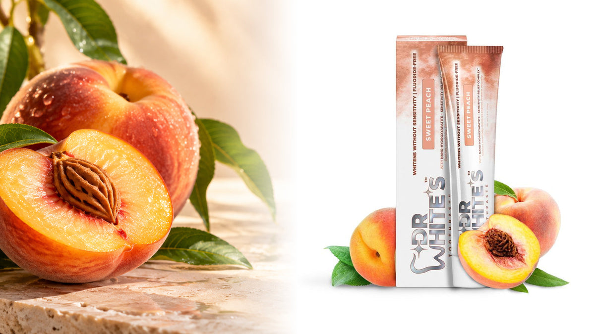 Dr. White’s Sweet Peach toothpaste tube and carton from the current catalog, paired with sunlit peaches and warm stone.